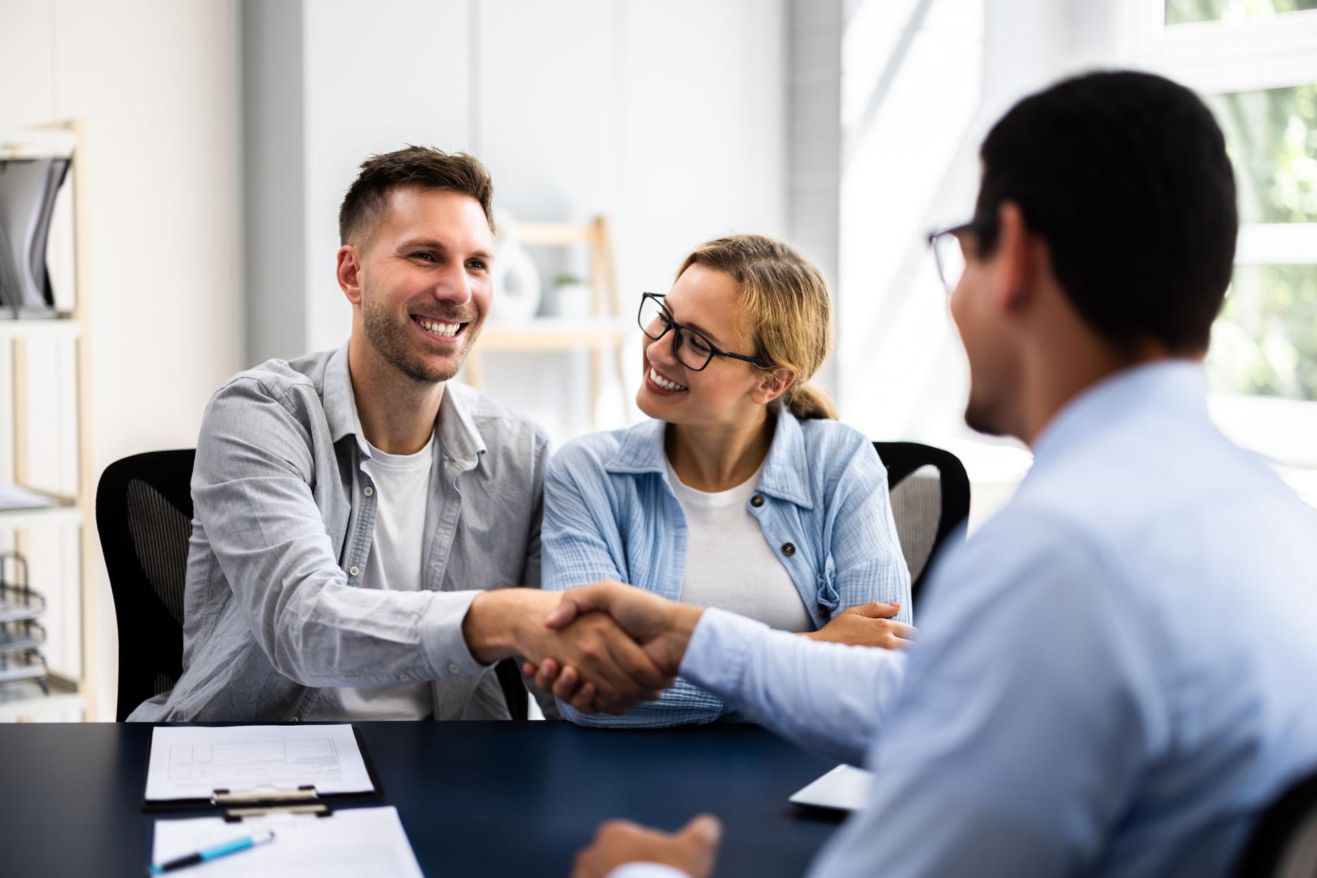 Young couple signing rental contract with real estate agent at apartment viewing